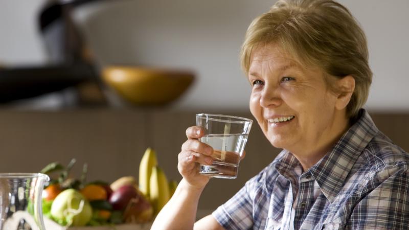 oudere vrouw drinkt glas water